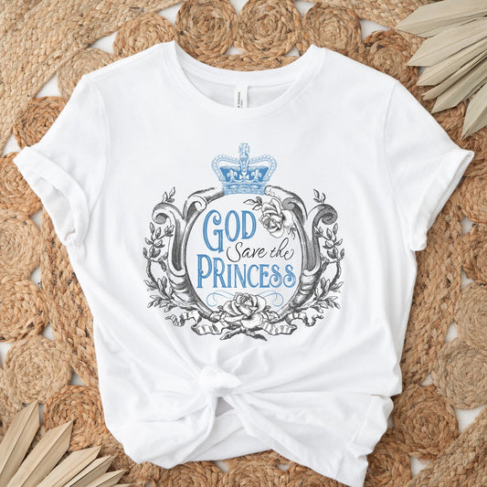 White soft vintage British Royal Family women's unisex t-shirt that says "God Save the Princess"  with Blue crown, roses, and baroque filigree frame design, created as a reminder to pray for the United Kingdom Princess of Wales, Kate Middleton in her battle with cancer