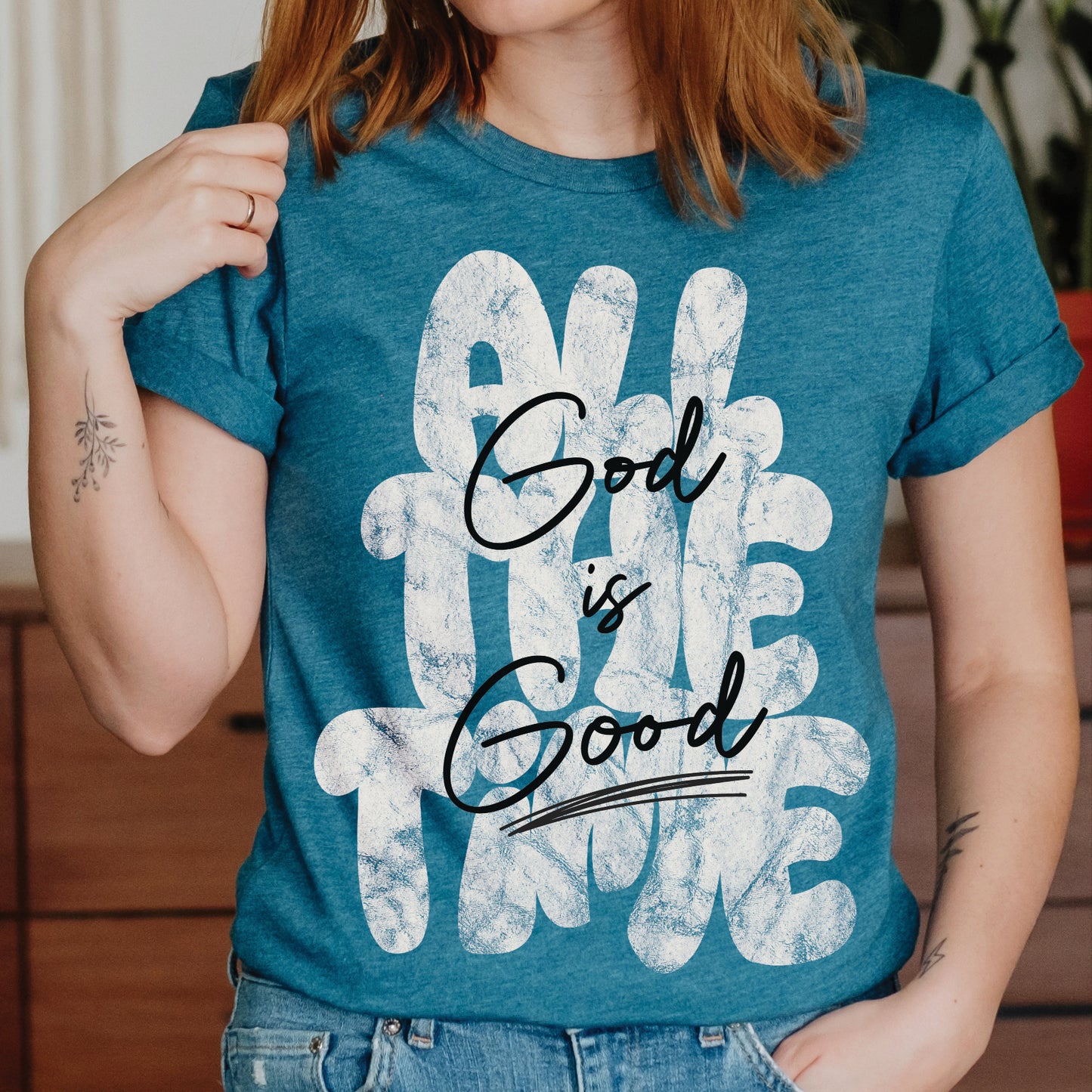Young woman wearing a Christian faith-based unisex heather deep teal t-shirt with inspirational quote 'God is Good All The Time' in modern trendy font – religious apparel for men and women