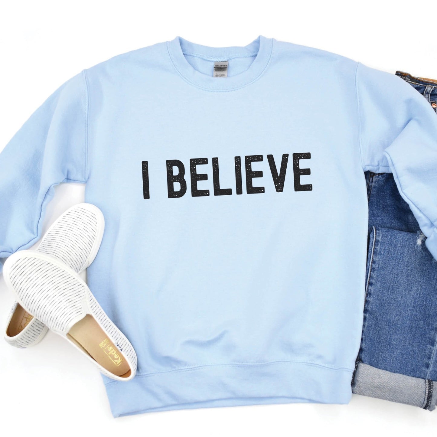 I Believe Christian aesthetic Jesus believer matte black simple distressed typography design printed on cozy light baby blue unisex crewneck sweatshirt, created for men & women