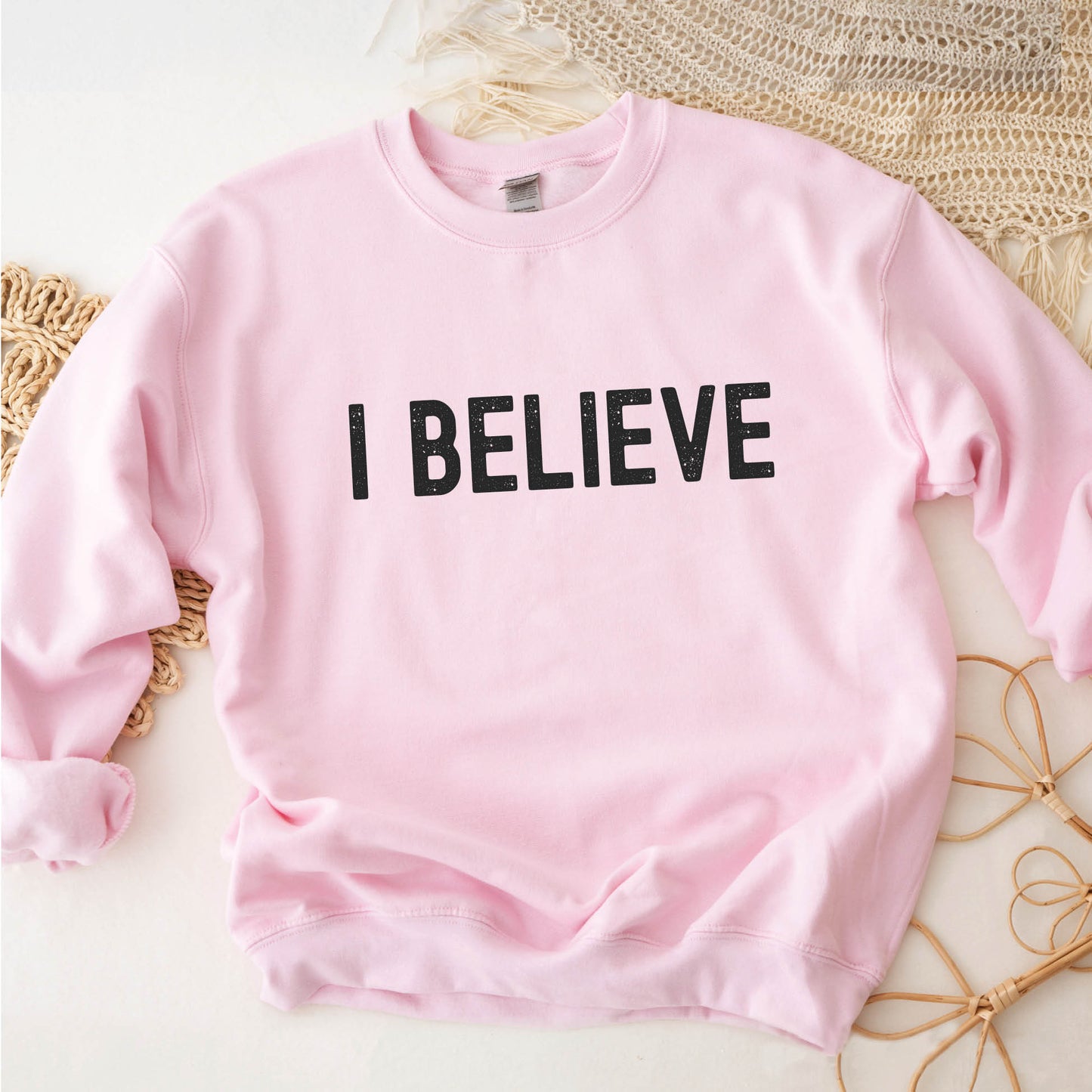 I Believe Christian aesthetic Jesus believer matte black simple distressed typography design printed on cozy light pink unisex crewneck sweatshirt, created for men & women