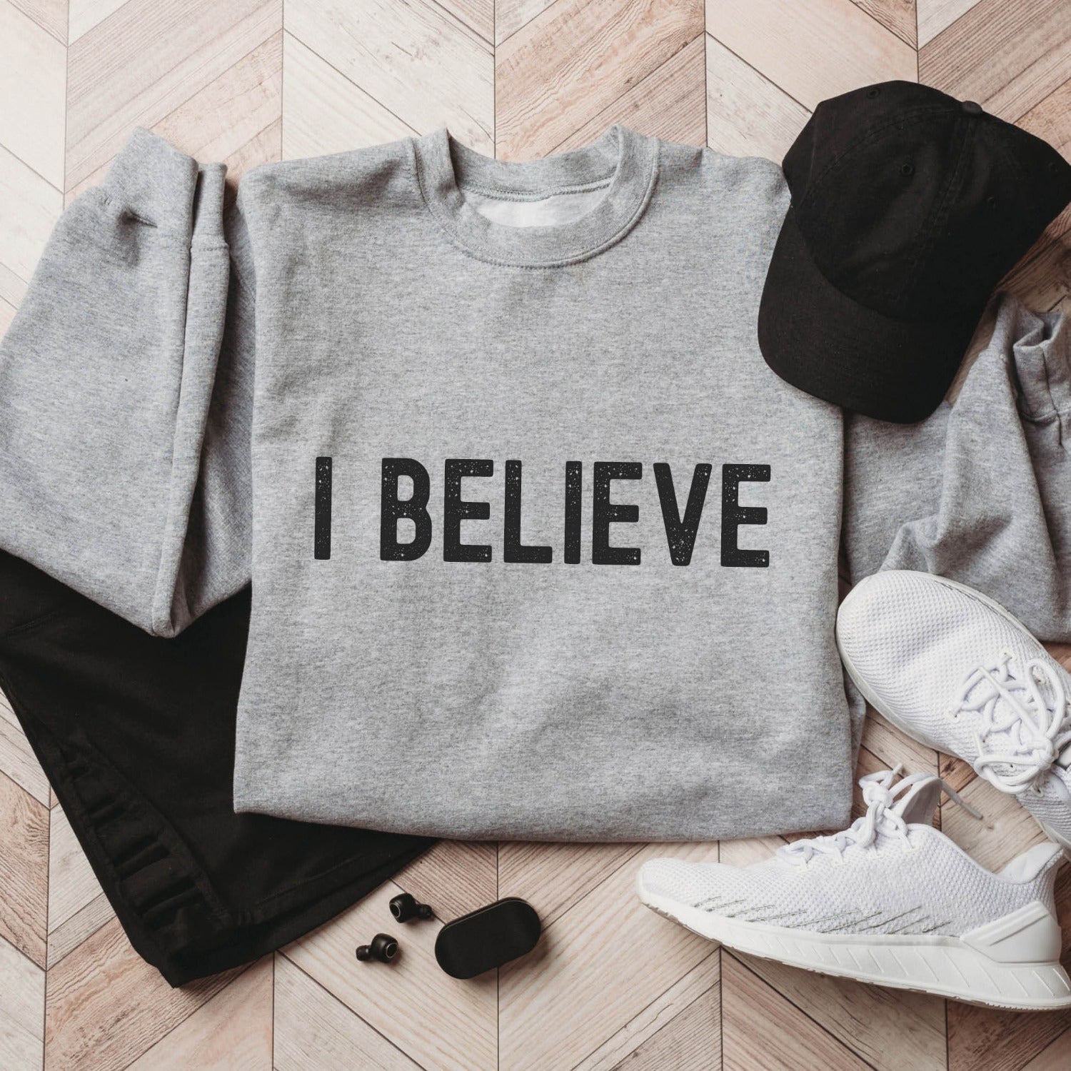 I Believe Christian aesthetic Jesus believer matte black simple distressed typography design printed on cozy heather sport gray unisex crewneck sweatshirt, created for men & women