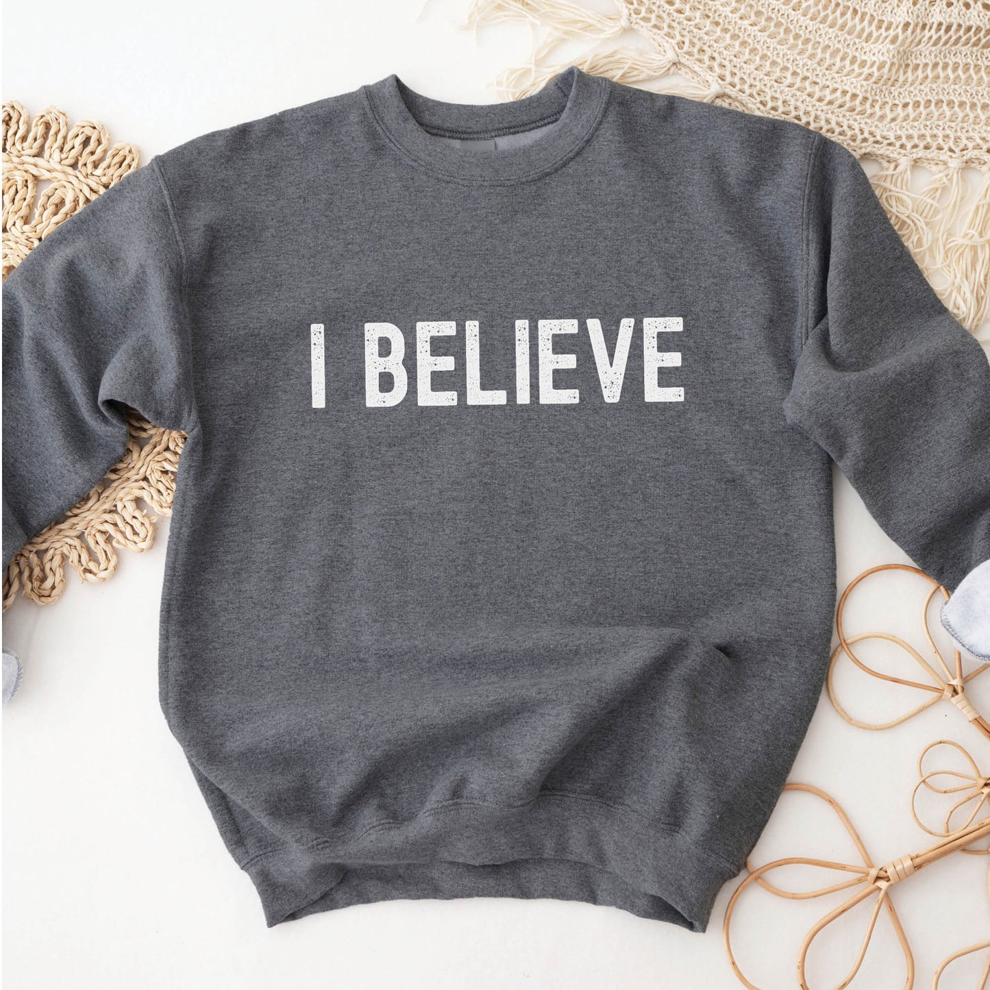 I Believe Christian aesthetic Jesus believer simple distressed white typography design printed on cozy heather dark gray unisex crewneck sweatshirt, created for men & women