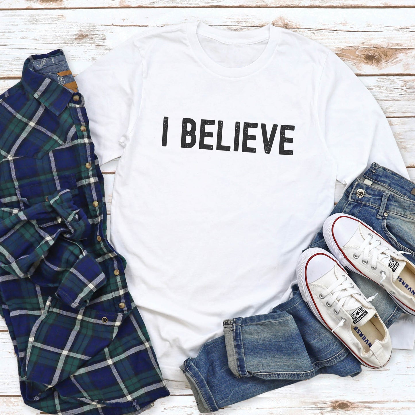 White cozy long sleeve t-shirt with a bold faith-based statement "I BELIEVE" distressed typography design printed in black, created for Christian men and women Jesus believers