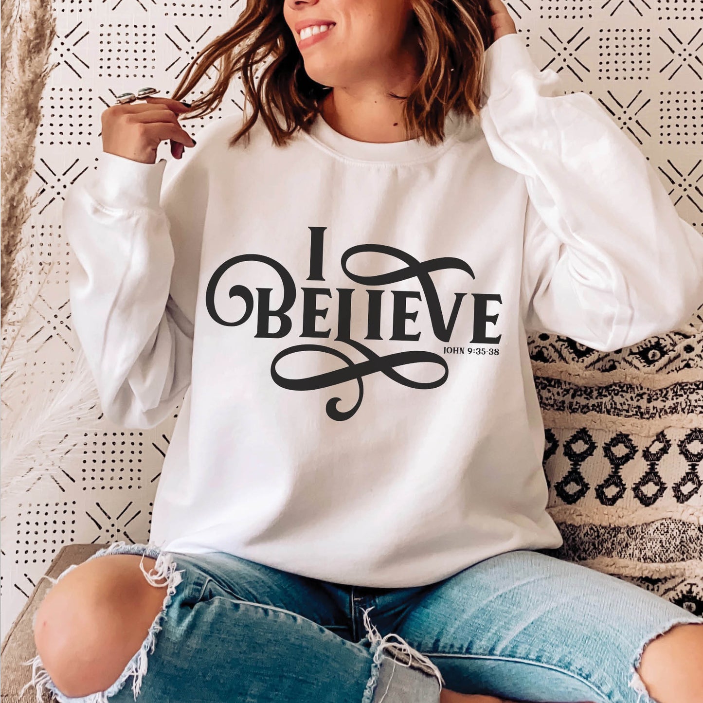 Young woman wearing a white I BELIEVE John 9:35-38 bible verse women's Christian unisex cozy sweatshirt, designed for faith-filled Jesus believers in size small, medium, large, XL, 2XL, 3XL, 4XL