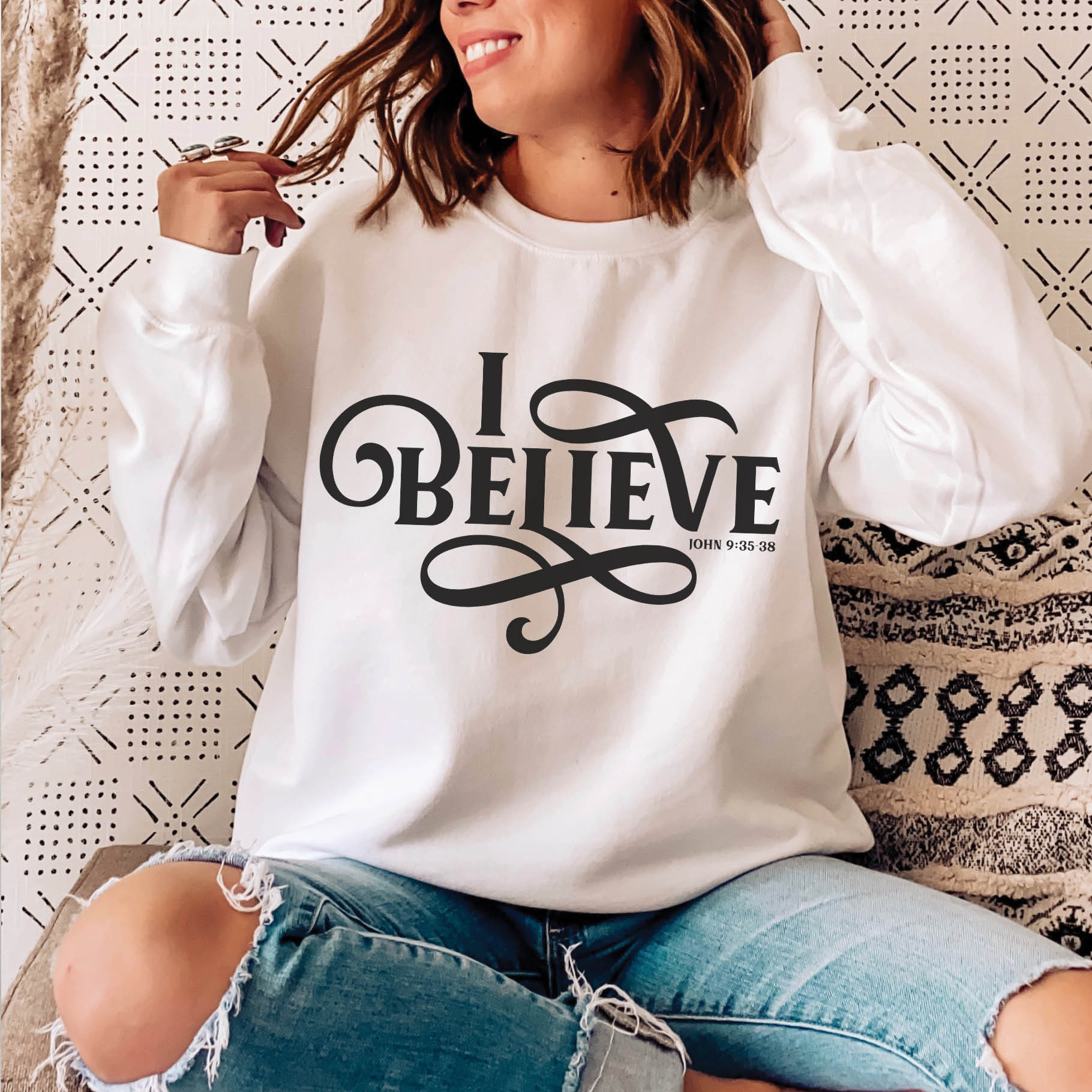 Young woman wearing a white I BELIEVE John 9:35-38 bible verse women's Christian unisex cozy sweatshirt, designed for faith-filled Jesus believers in size small, medium, large, XL, 2XL, 3XL, 4XL