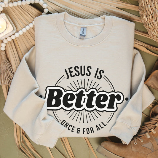 Sand color faith-based cozy sweatshirt with "Jesus is BETTER - Once and For All" logo style design in black and white, created for Christian men and women