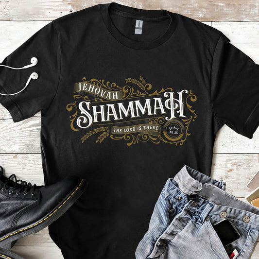 Black and gold Jehovah Shammah "The Lord Is There" men's Christian unisex black t-shirt from Ezekiel 38:35 vision bible verse Hebrew meaning, with manly vintage blackletter and ornate decorative swirl filigree design, created for men and women believers