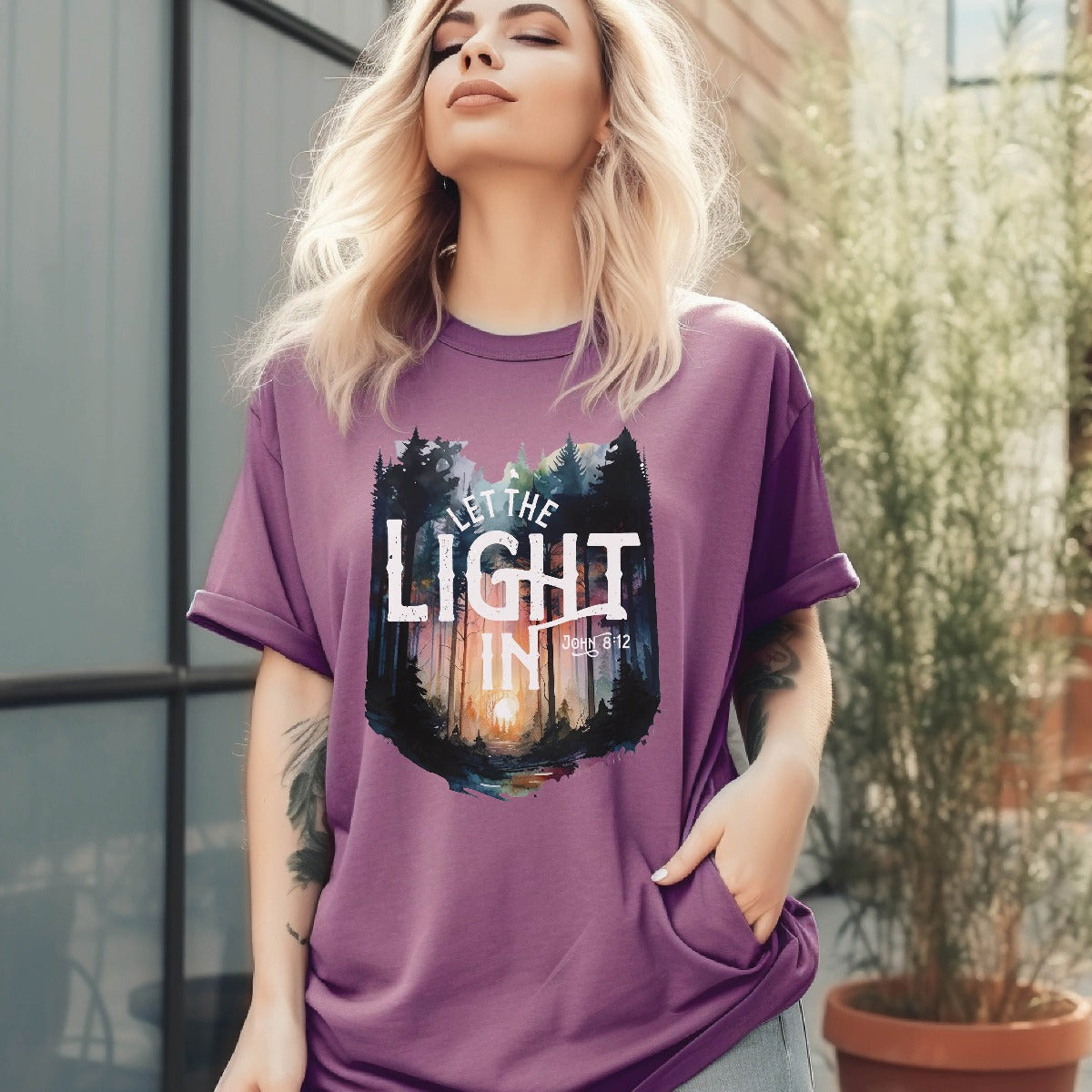 Berry garment dyed Comfort Colors C1717 unisex faith-based Christian t-shirt with "Let the Light In" John 8:12 bible verse and watercolor moody forest trees scene, designed for men and women