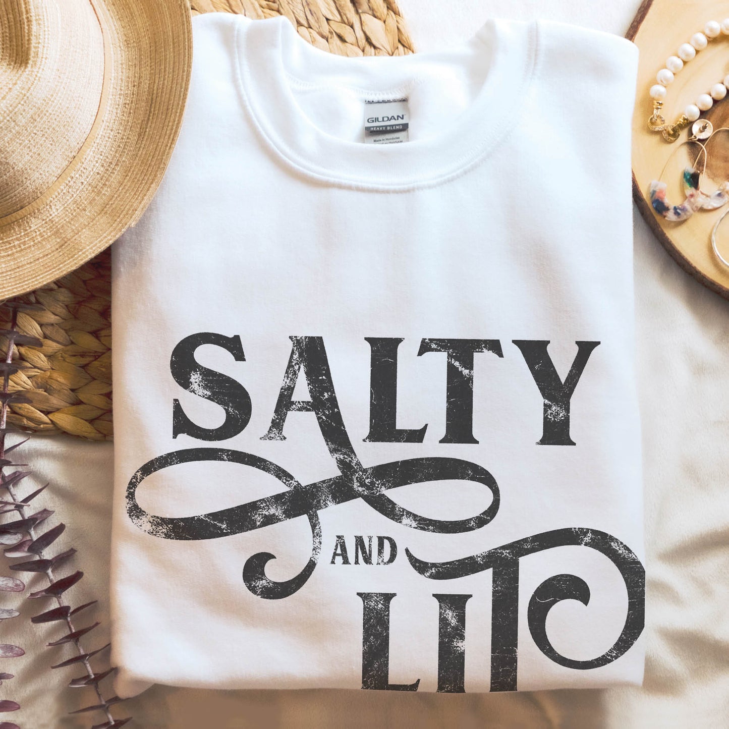 Salty And Lit Matthew 5:13-14 bible verse funny Christian aesthetic unisex crewneck sweatshirt with distressed swirl typography design printed in charcoal gray on cozy white sweater for women