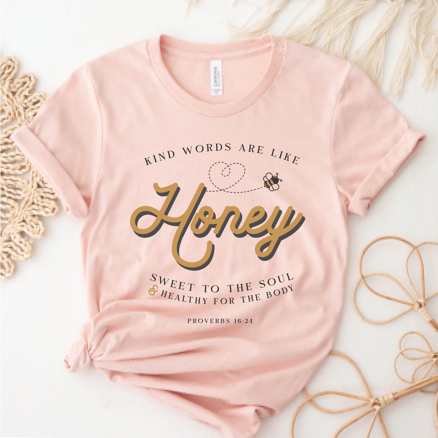 Heather peach & gold Christian aesthetic unisex faith-based kindness bee t-shirt for women with Proverbs 16:24 bible verse quote that says, "Kind Words Are Like Honey, Sweet To the Soul, and Healthy For the Body"