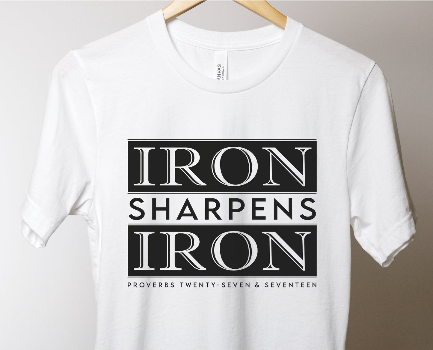 Iron Sharpens Iron Proverbs 27:17 Christian aesthetic block style design printed in black on soft white unisex t-shirt for men's groups