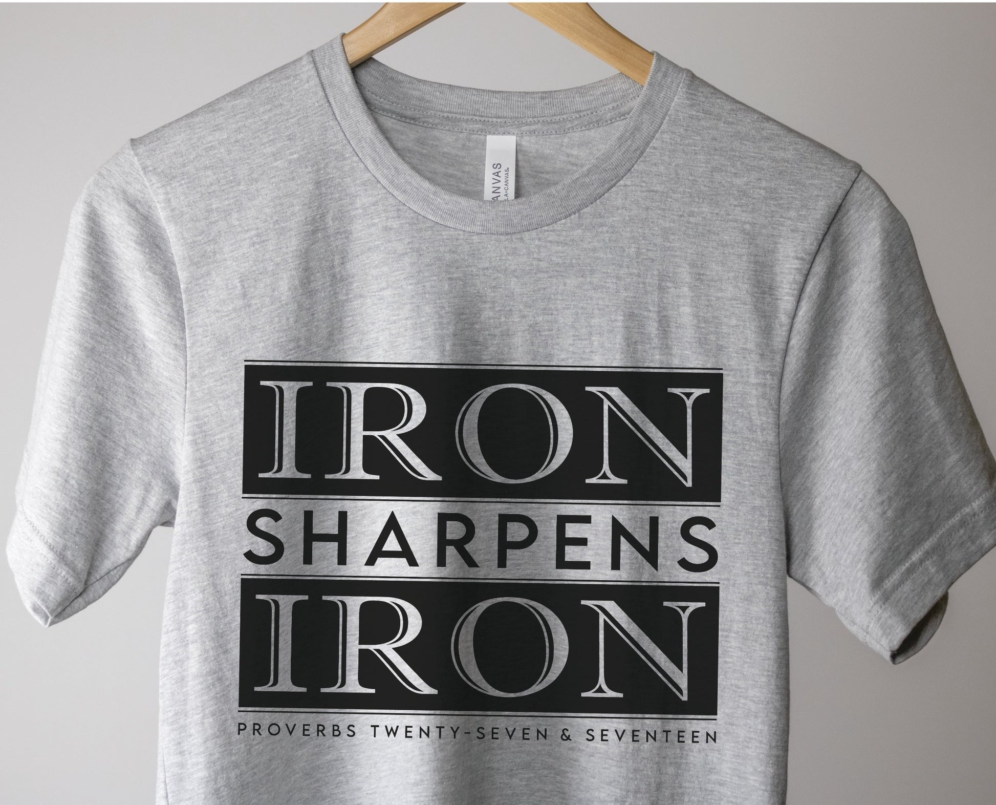 Iron Sharpens Iron Proverbs 27:17 Christian aesthetic block style design printed in black on soft heather gray unisex t-shirt for men's groups