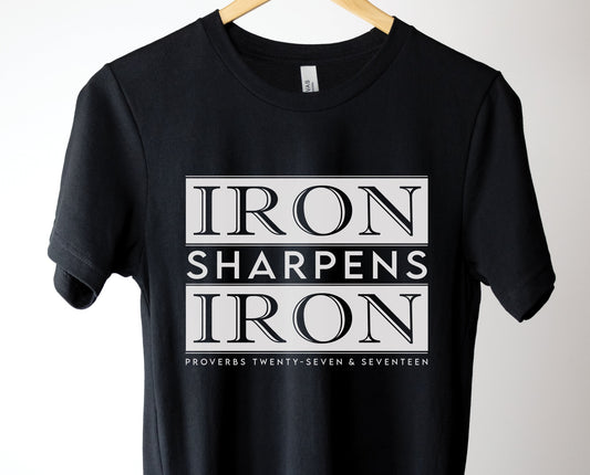 Iron Sharpens Iron Proverbs 27:17 Christian aesthetic block style design printed in white on soft black unisex t-shirt for men's groups