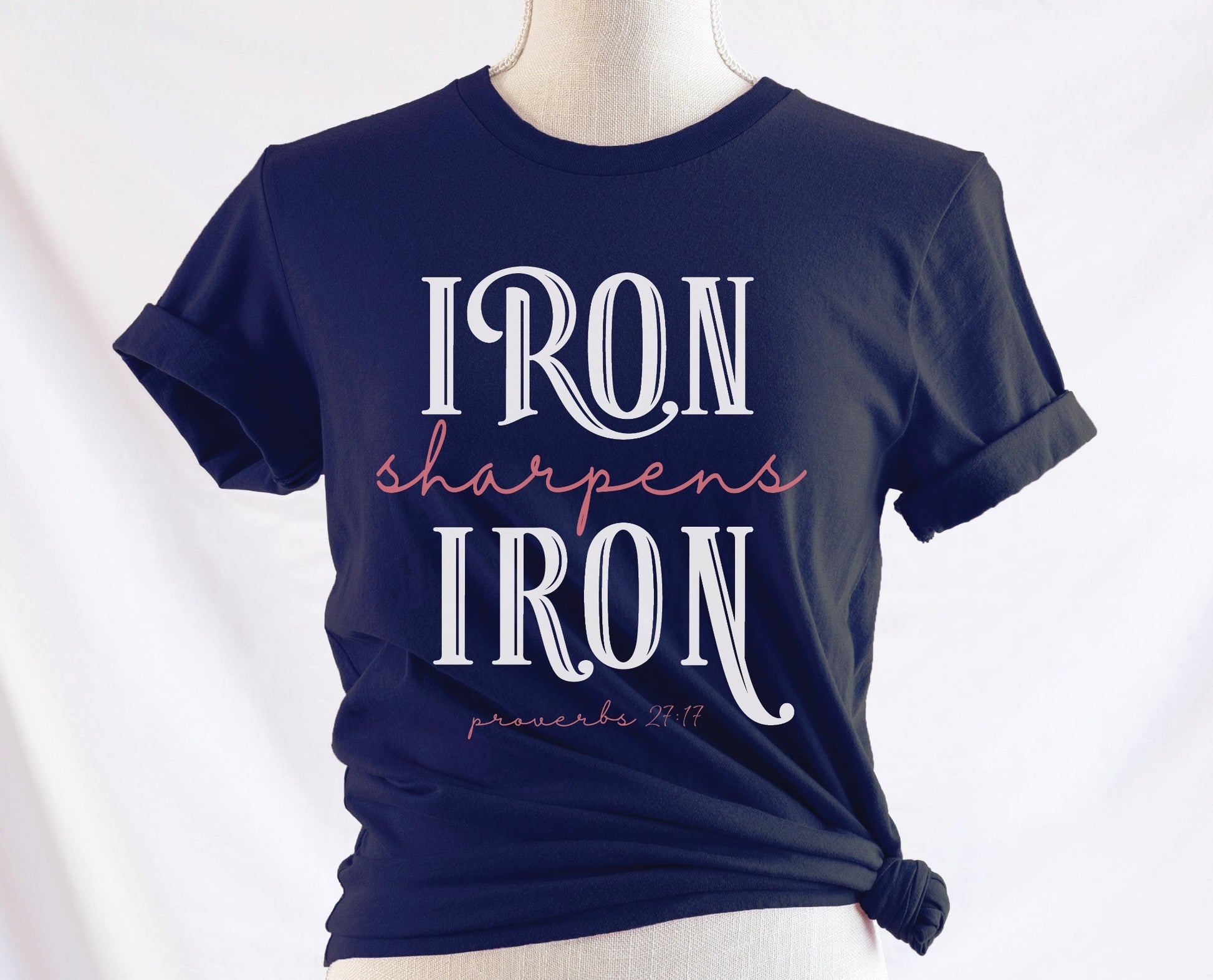 Iron Sharpens Iron Proverbs 27:17 Christian aesthetic design printed in white and mauve on ladies soft navy blue unisex t-shirt for women's groups