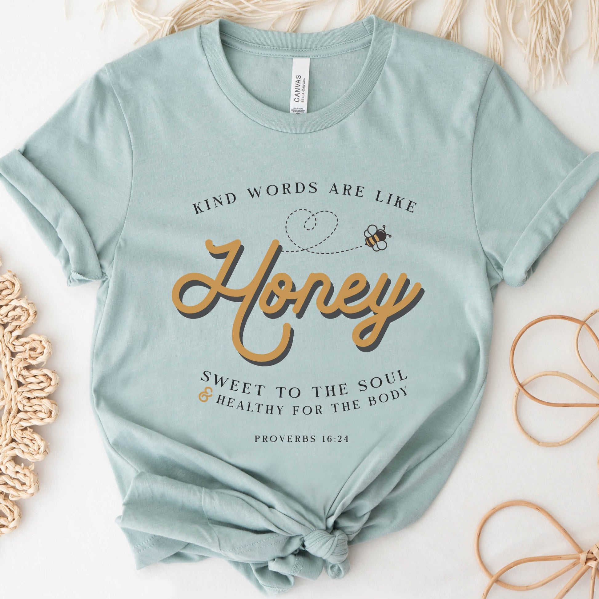 Dusty blue & gold Christian aesthetic unisex faith-based kindness bee t-shirt for women with Proverbs 16:24 bible verse quote that says, "Kind Words Are Like Honey, Sweet To the Soul, and Healthy For the Body"