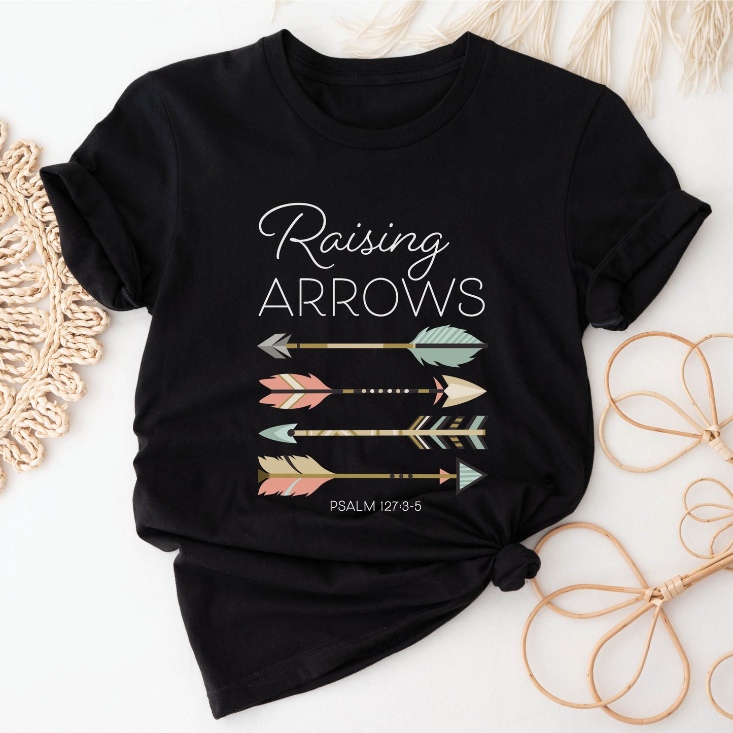 Boho Raising Arrows Psalm 127 Quiver Full Christian aesthetic faith-based design printed in peach, cream, light teal, gold, and white on soft black unisex t-shirt for women and Moms