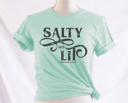 Salty And Lit Matthew 5:13-14 bible verse funny Christian T-Shirt design printed in charcoal gray on soft heather prism mint green tee for women