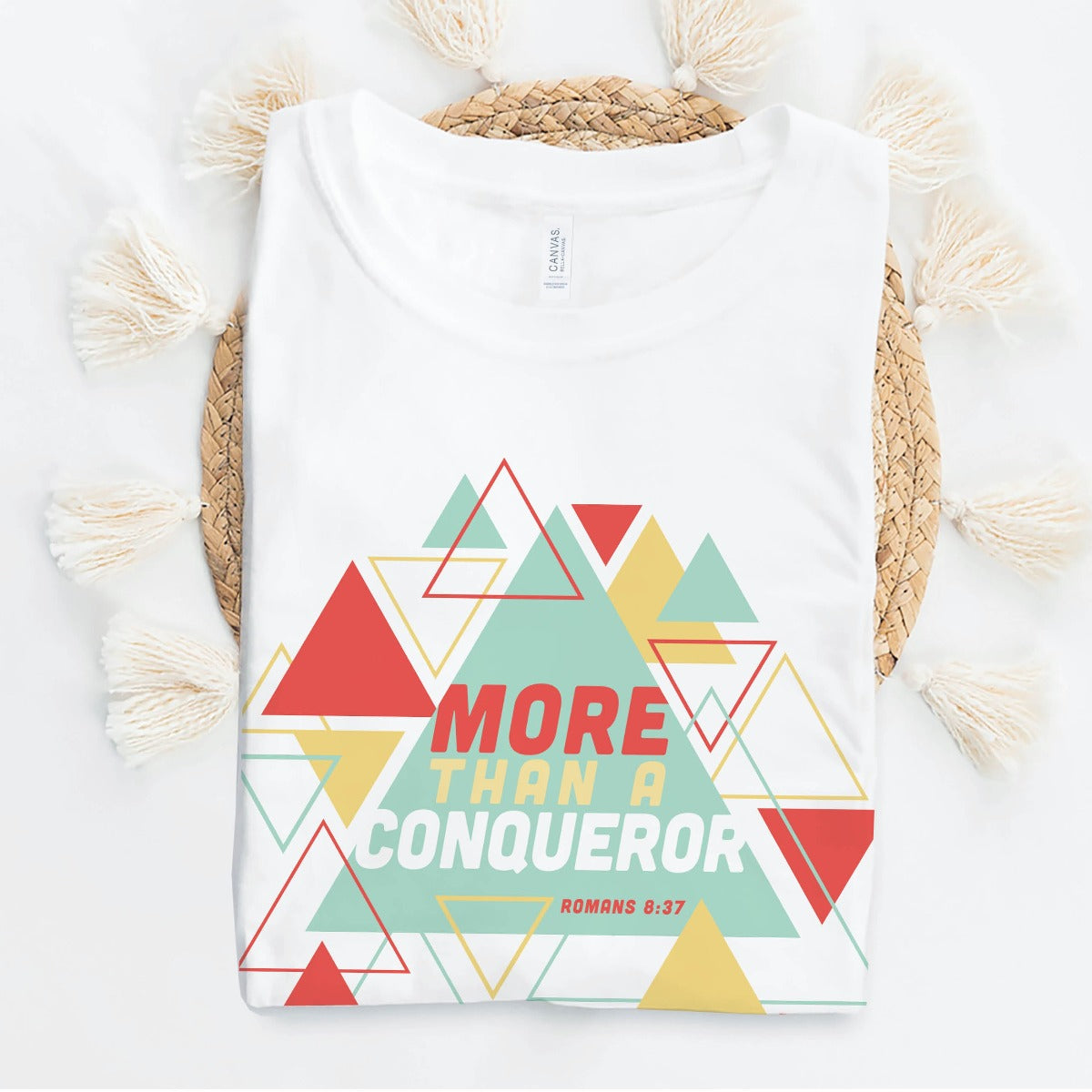 White "More Than A Conqueror" Romans 8:37 bible verse scripture unisex faith-based Christian Bella Canvas 3001 t-shirt, with bright and colorful geometric triangles pattern, made in the USA for Men and Women Jesus believers
