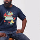 Man showing his strength in God wearing a navy blue "More Than A Conqueror" Romans 8:37 bible verse scripture unisex faith-based Christian Bella Canvas 3001 t-shirt, with bright and colorful geometric triangles pattern, made in the USA for Men and Women Jesus believers