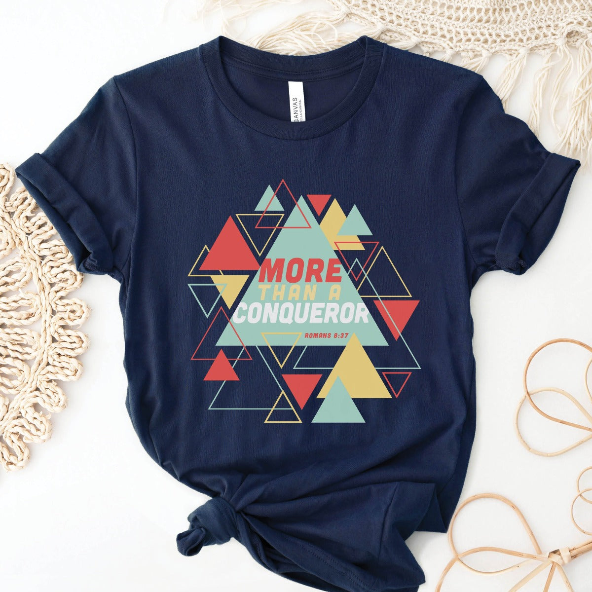 Navy blue "More Than A Conqueror" Romans 8:37 bible verse scripture unisex faith-based Christian Bella Canvas 3001 t-shirt, with bright and colorful geometric triangles pattern, made in the USA for Men and Women Jesus believers