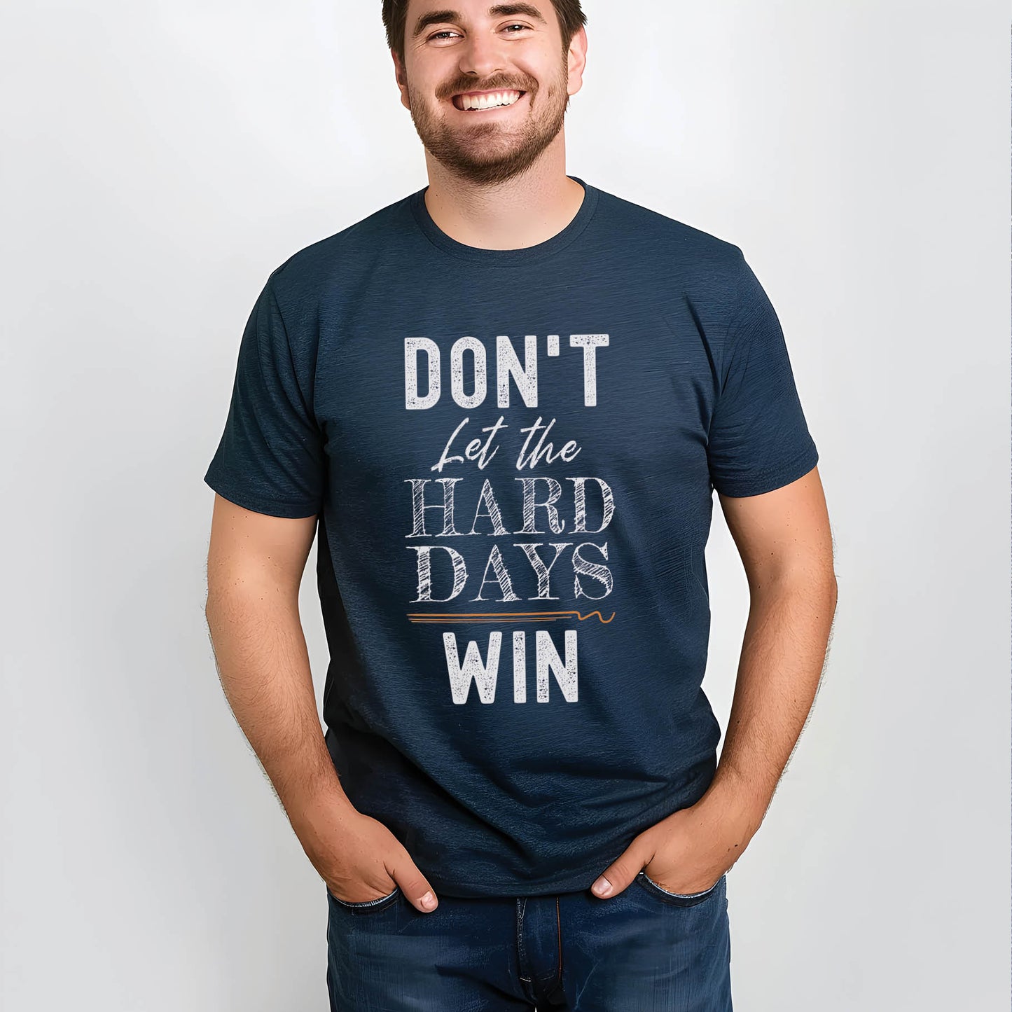 Young man, husband, dad wearing a faith-based "Don't Let the Hard Days Win" Christian men's soft navy blue unisex t-shirt with bold typography design printed in white, great father's day gift for the encourager in your life