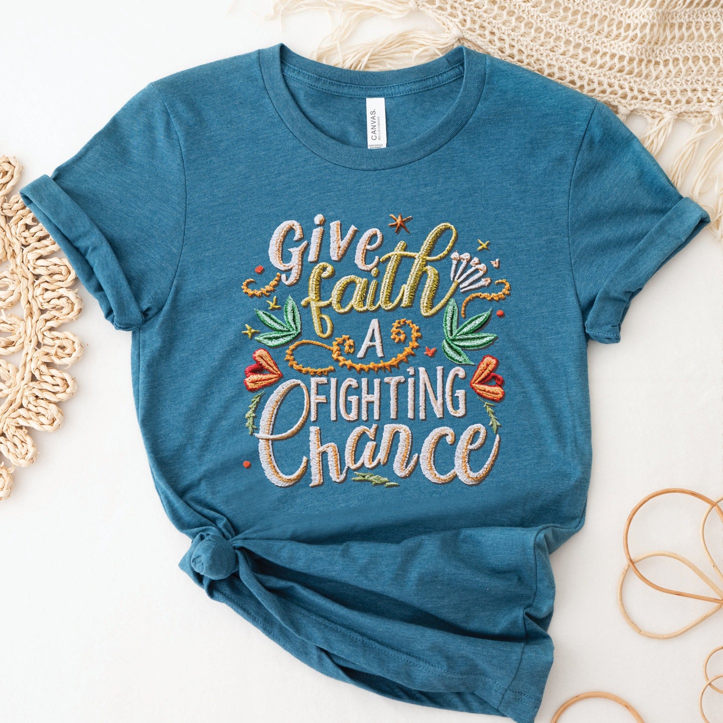 Heather deep teal soft t-shirt with printed embroidery font Christian Bible verse quote that says, "Give Faith A Fighting Chance" with flower and leaf graphics, faith-based t-shirt designed for women