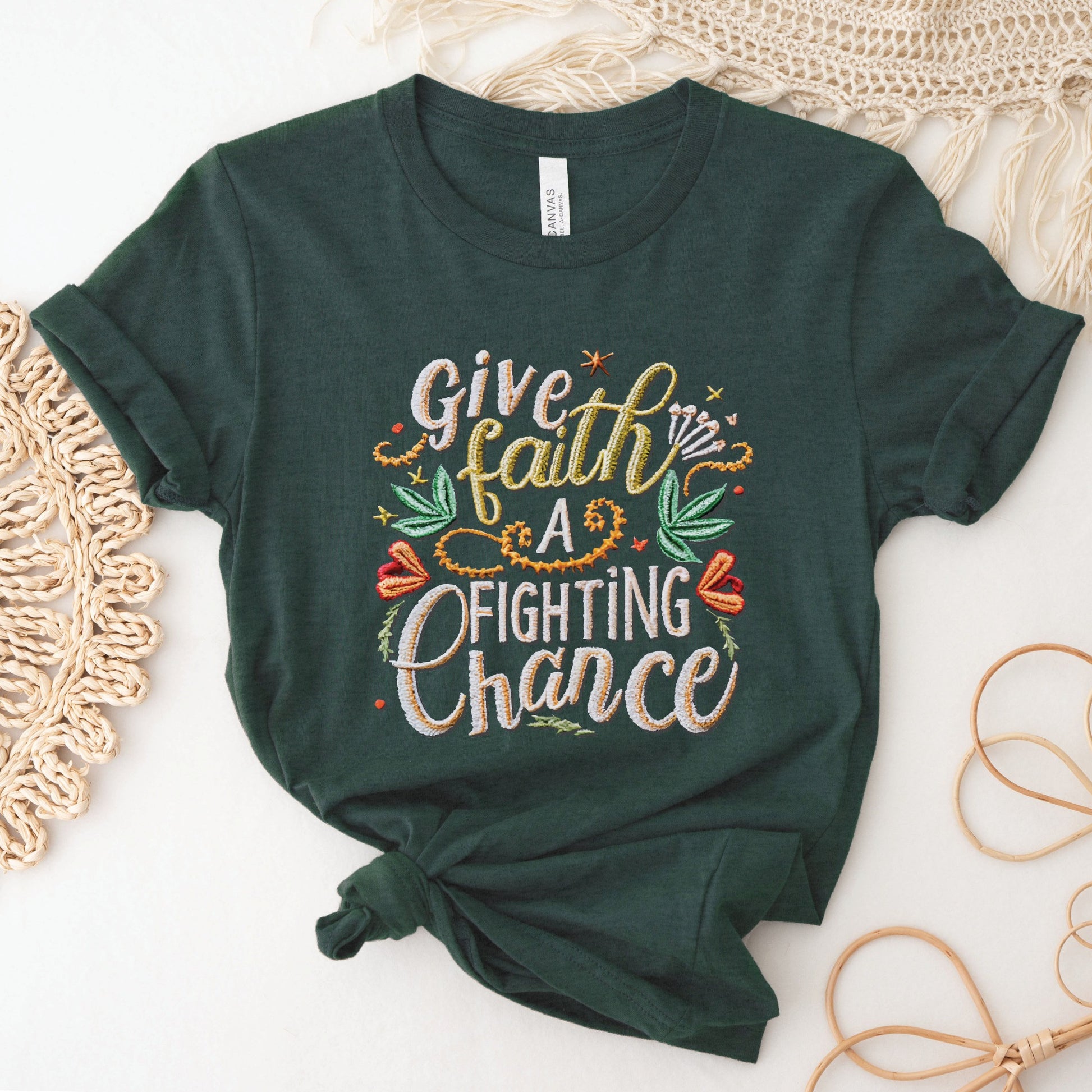 Heather forest dark green soft t-shirt with printed embroidery font Christian Bible verse quote that says, "Give Faith A Fighting Chance" with flower and leaf graphics, faith-based t-shirt designed for women