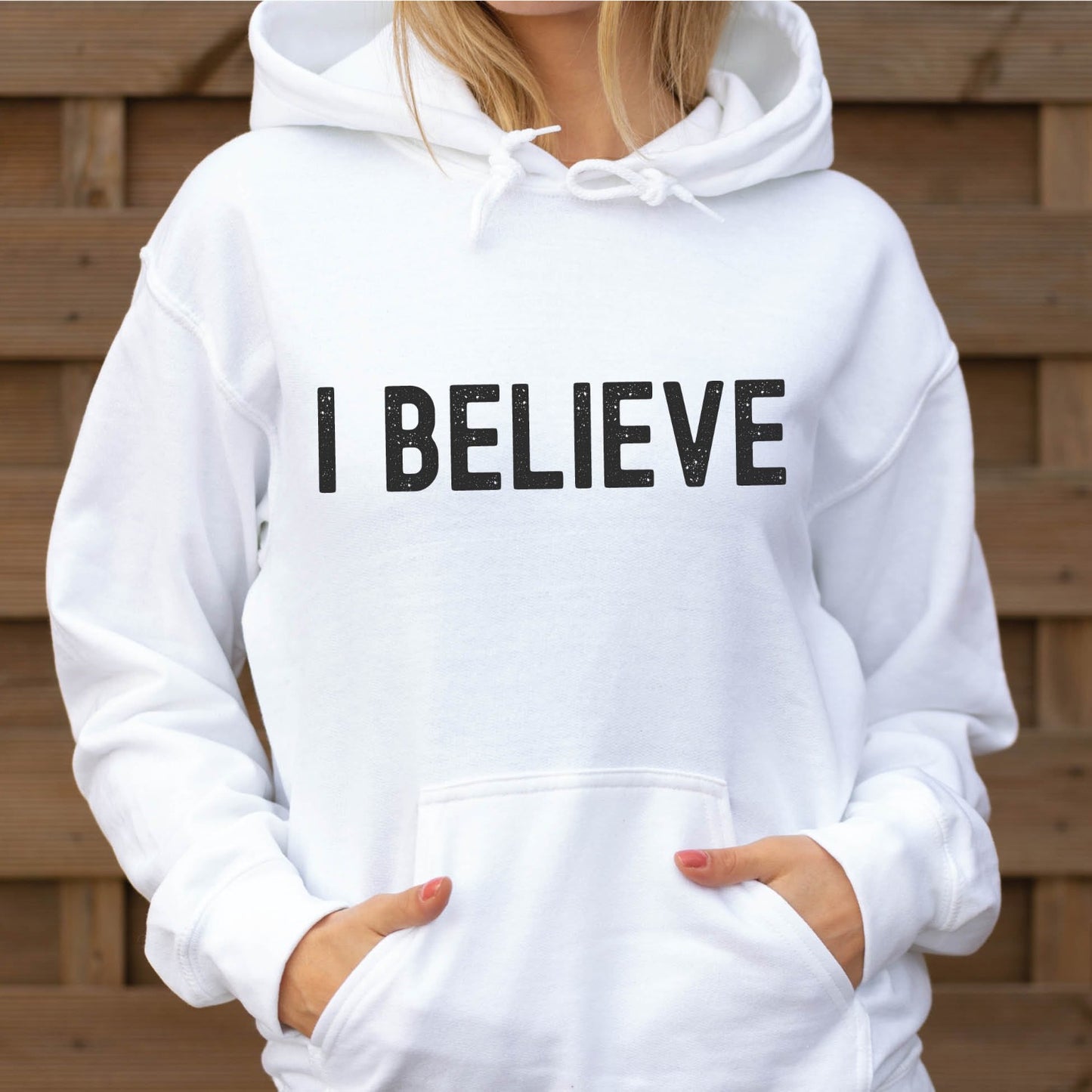 Faith-based "I Believe" Christian aesthetic faith statement design printed in distressed black words on cozy white unisex hoodie sweatshirt, created for Christian men and women