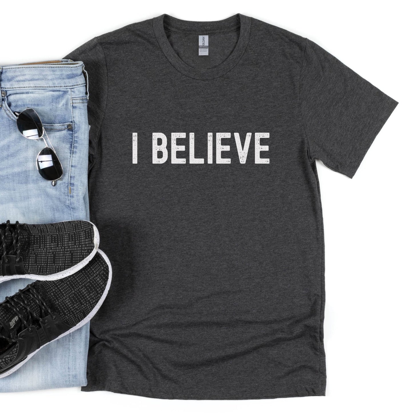 I BELIEVE Christian aesthetic faith-based bold statement distressed typography t-shirt design printed in white on soft heather dark gray unisex fit t-shirt, designed for men & women believers
