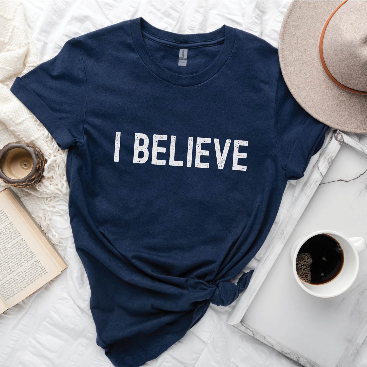 I BELIEVE Christian aesthetic faith-based bold statement distressed typography t-shirt design printed in white on soft navy blue unisex fit t-shirt, designed for men & women believers
