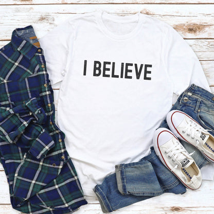 White cozy long sleeve t-shirt with a bold faith-based statement "I BELIEVE" distressed typography design printed in black, created for Christian men and women Jesus believers