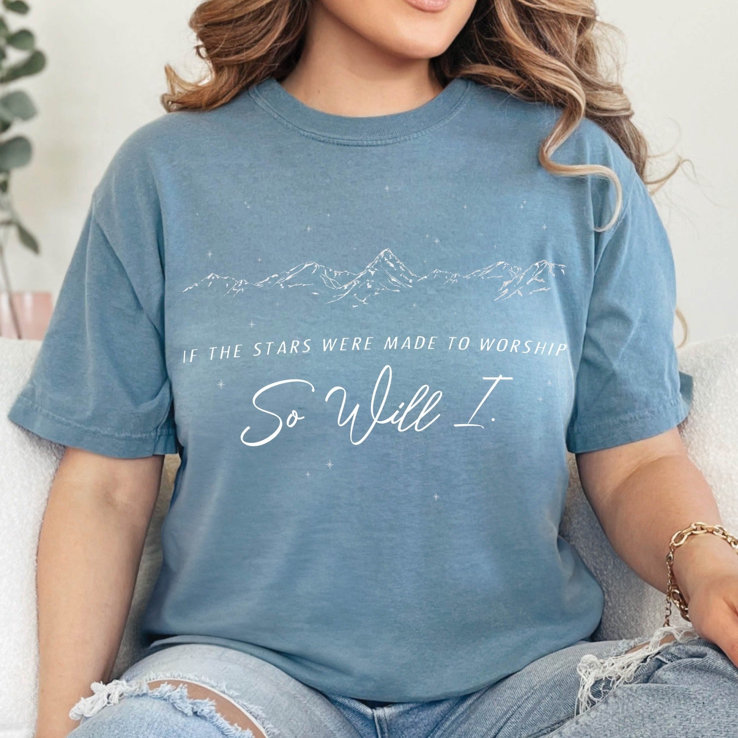 Woman wearing an oversized dusty ice blue color garment-dyed unisex Comfort Colors 1717 t-shirt with a white hand-drawn mountain range and starry sky that says this faith-based bible verse quote, "If the Stars Were Made to Worship So Will I", created for Christian men and women Kingdom believers