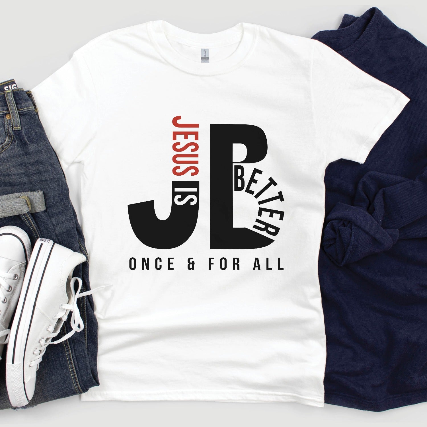 "JB" typography "Jesus is Better Once and For All" design in black and red letters, based on the Christian bible book of Hebrews, printed on a white color Unisex t-shirt, created for faith-based men and women, great father's day gift for dad