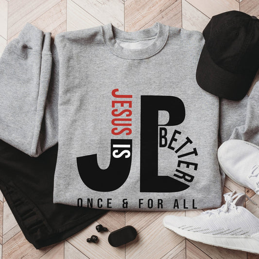 "JB" typography "Jesus is Better Once and For All" design in black and red letters, based on the Christian bible book of Hebrews, printed on a heather sport gray color Unisex crewneck sweatshirt, created for faith-based men and women, great father's day gift for Dad