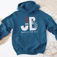 "JB" typography "Jesus is Better Once and For All" design in white and red letters, based on the Christian bible book of Hebrews, printed on a indigo blue color cozy unisex hoodie, created for faith-based men and women, great father's day gift for Dad