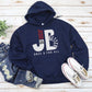 "JB" typography "Jesus is Better Once and For All" design in white and red letters, based on the Christian bible book of Hebrews, printed on a navy blue color cozy unisex hoodie, created for faith-based men and women, great father's day gift for Dad