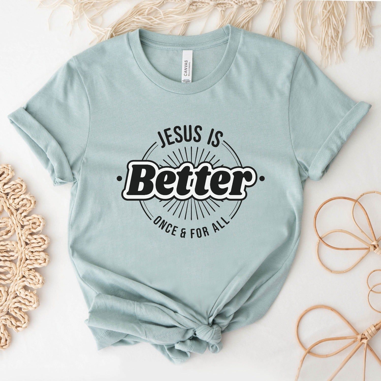 Heather Prism Dusty Blue "Jesus Is Better - Once & For All" bible book of Hebrews faith-based Christian unisex t-shirt for women with a bold white and black sunburst logo style design