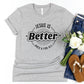 Athletic Heather Gray "Jesus Is Better - Once & For All" bible book of Hebrews faith-based Christian unisex t-shirt for women with a bold black and white sunburst logo style design