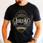 Young man wearing a black Christian faith-based unisex t-shirt featuring a gold ornamental blackletter-style frame design with the text 'Jehovah Jireh The Lord My Provider' and 'Genesis 22:14' Bible verse, unique and inspirational religious apparel for regular and plus size men and women