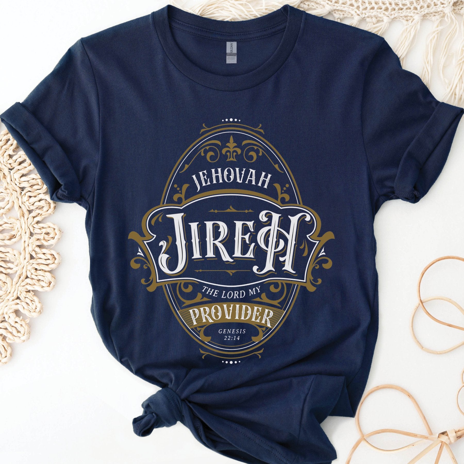 Navy blue and gold Christian faith-based unisex t-shirt featuring a gold ornamental blackletter-style frame design with the text 'Jehovah Jireh The Lord My Provider' and 'Genesis 22:14' Bible verse, unique and inspirational religious apparel for regular and plus size men and women