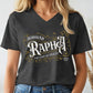 Dark heather gray V-neck women's Christian t-shirt with 'Jehovah Rapha, The Lord My Healer, Exodus 18:26 bible verse' vintage blackletter style design worn by a woman