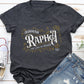 Dark heather gray V-neck women's Christian t-shirt with 'Jehovah Rapha, The Lord My Healer, Exodus 18:26 bible verse' vintage blackletter style design laying flat on a white wooden surface with jeans and sneakers