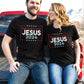 Patriotic couple wearing black stars and stripes Presidential election vote unisex Christian t-shirt, Jesus 2024 Keep America Saved" in bold red, white, and blue fonts, made in the USA, made for men and women God & Country Patriots