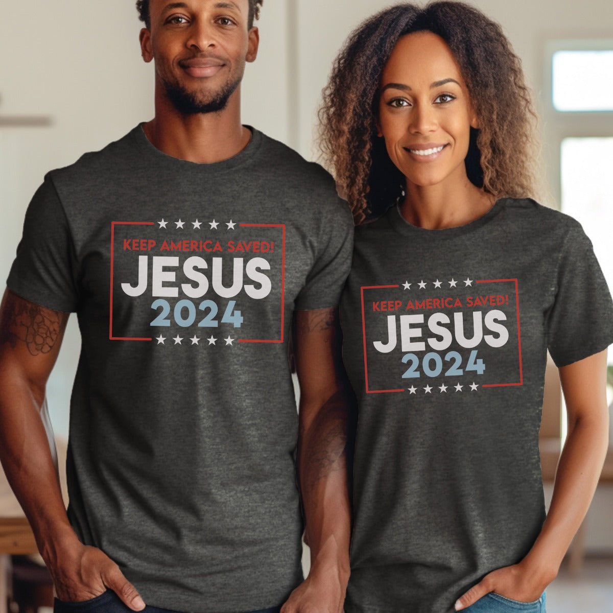 Patriotic couple wearing a heather dark gray stars and stripes Presidential election vote unisex Christian t-shirts that say "Jesus 2024 Keep America Saved" in bold red, white, and blue fonts, made in the USA for men and women God & Country Patriots