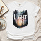 White Comfort Colors C1717 unisex faith-based Christian t-shirt with "Let the Light In" John 8:12 bible verse and watercolor moody forest trees scene, designed for men and women