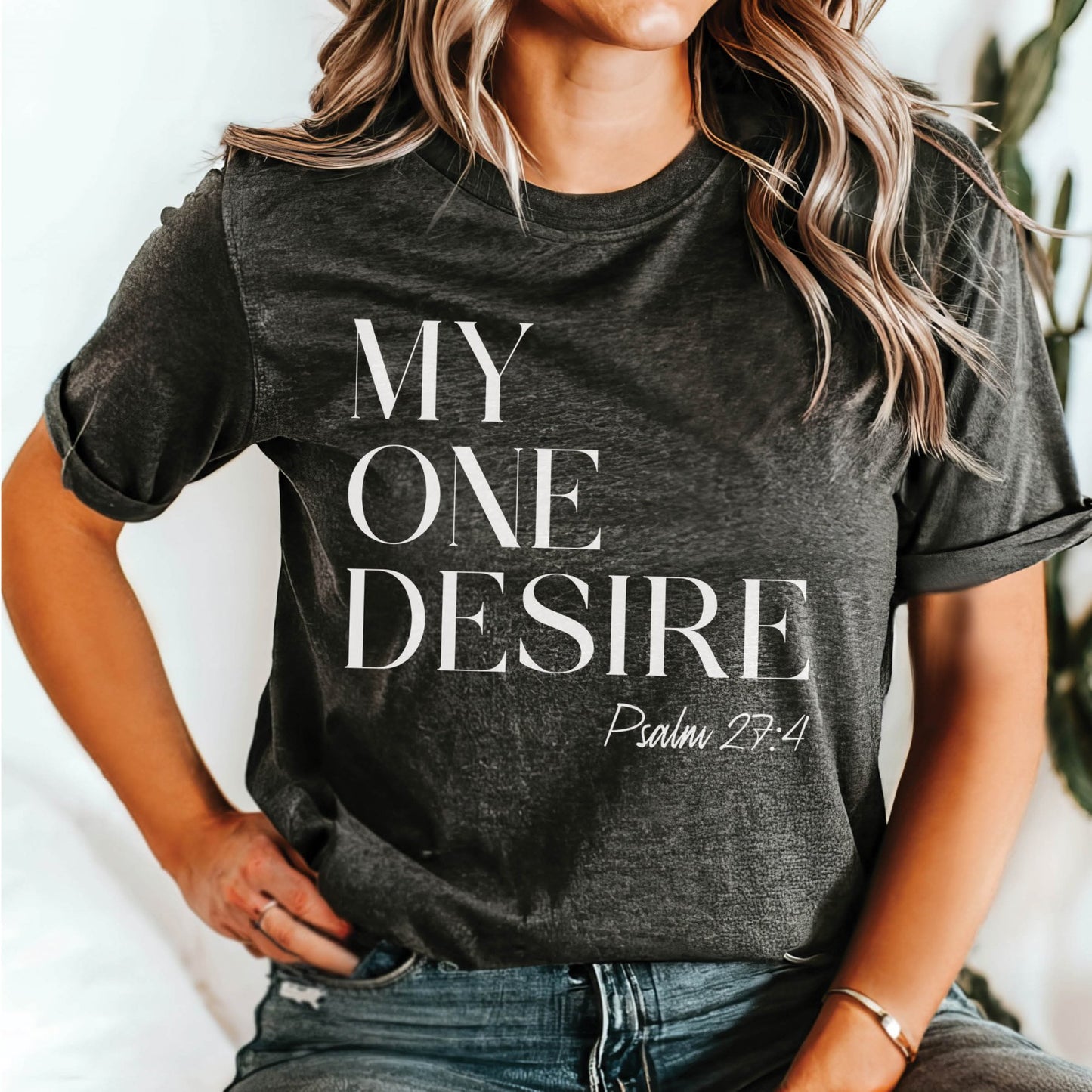 Trendy young woman wearing a "My One Desire - Psalm 27:4" bible verse heather dark gray Bella Canvas 3001 unisex Christian t-shirt for those who seek after God