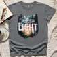 Gray color garment dyed Comfort Colors C1717 unisex faith-based Christian t-shirt with "Out of Darkness, Into Light" 1 Peter 2:9 bible verse and watercolor moody forest trees outdoor scene, designed for men and women