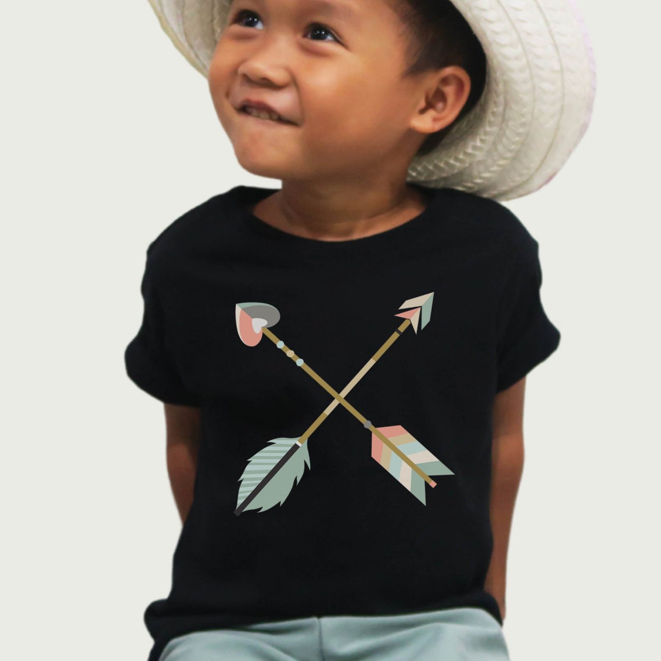 Cute toddler boy wearing a black kids Christian t-shirt with pastel boho criss-cross arrows for matching mommy-and-me Psalm 127:3-5 Raising a Quiver Full of Arrows bible verse women's tee