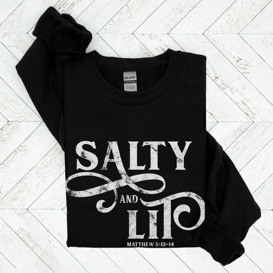Salty And Lit Matthew 5:13-14 bible verse funny Christian aesthetic unisex crewneck sweatshirt with distressed swirl typography design printed in white on cozy black sweater for women
