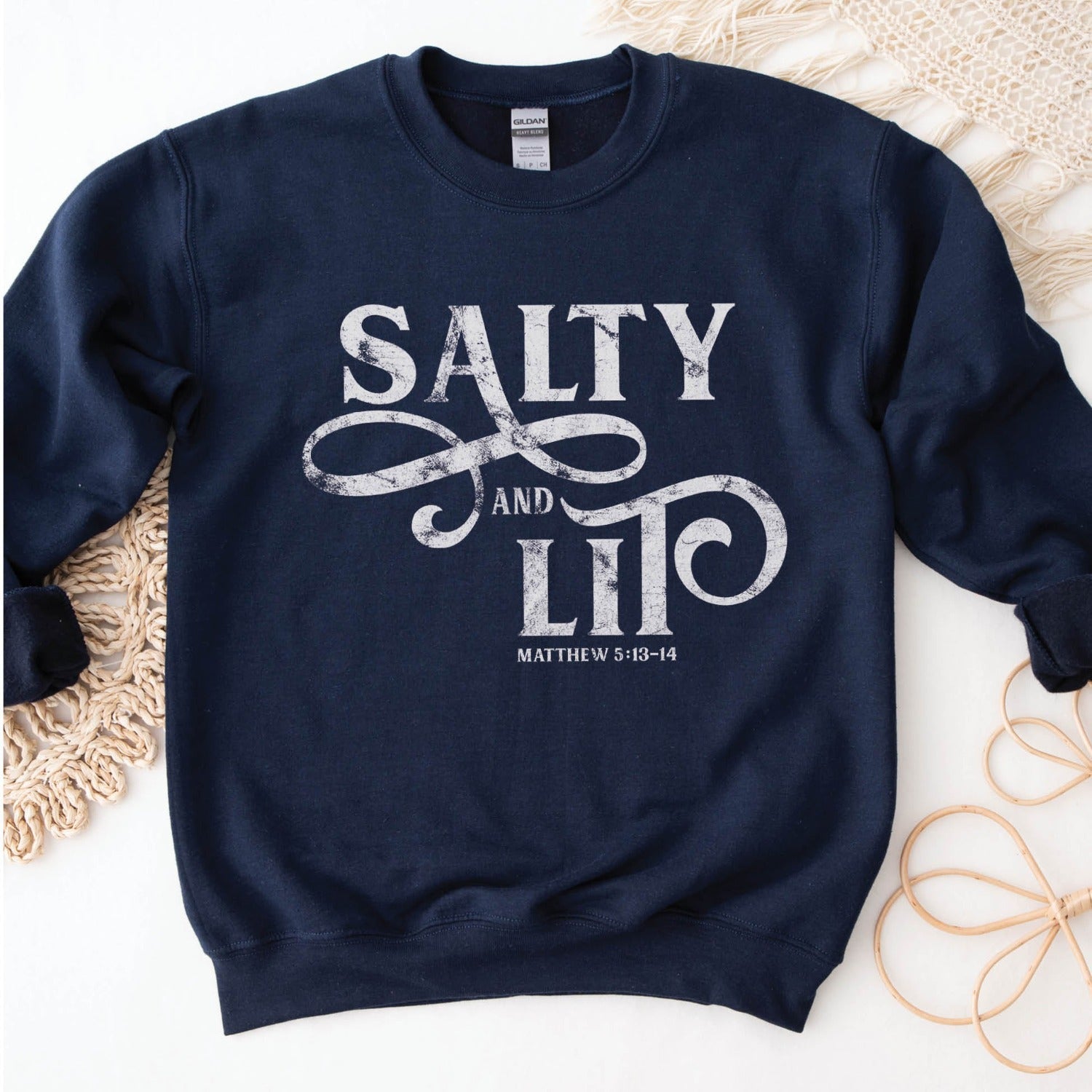Salty And Lit Matthew 5:13-14 bible verse funny Christian aesthetic unisex crewneck sweatshirt with distressed swirl typography design printed in white on cozy navy blue sweater for women